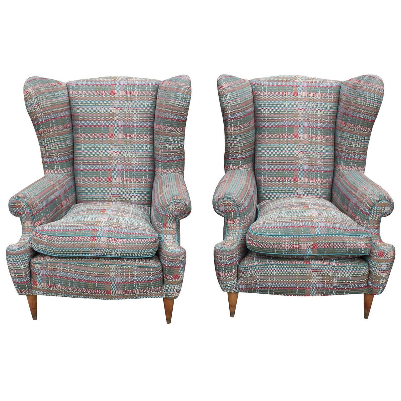 Great pair of oversized Italian wingback lounge chairs. Chairs have lovely curved lines and delicate tapered legs. Chairs are currently upholstered in a colorful tweed which is worn in some areas-could use new upholstery.
