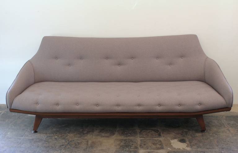 Impressive Adrian Pearsall Style restored gondola sofa in grey upholstry. Medium Walnut wood trim lines the base.