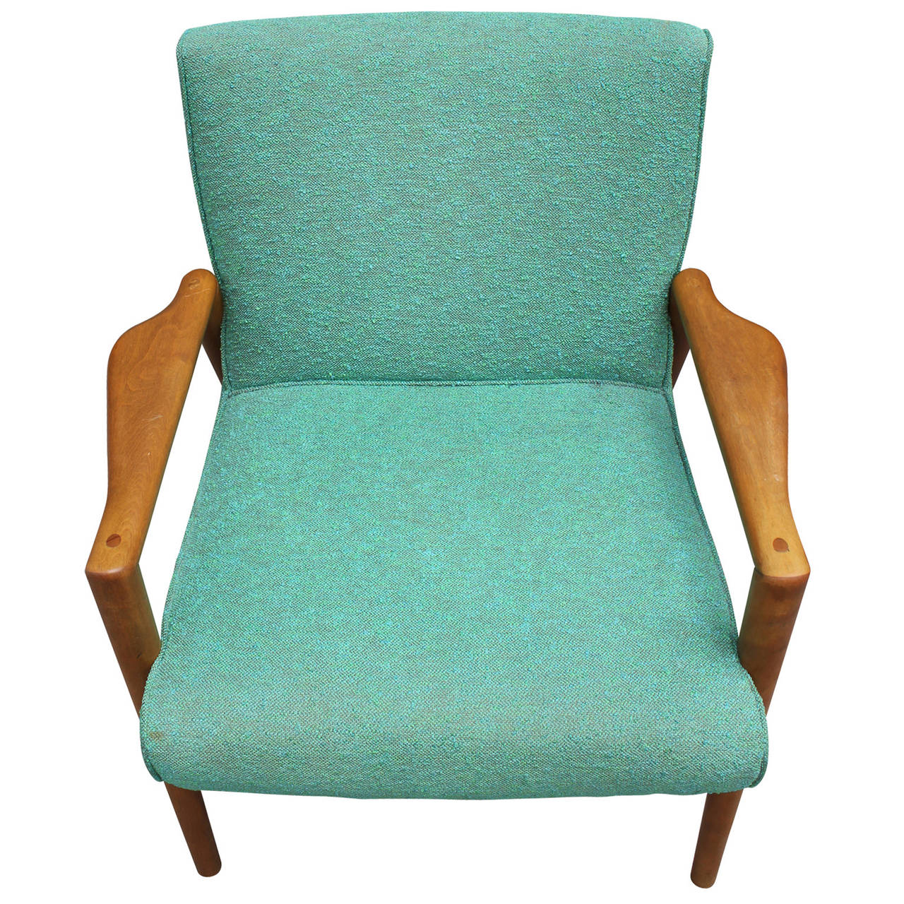 Lovely Danish style arm chair. Chair is upholstered in an original textured kelly green fabric. Blonde wood arms angle out to create visual interest.