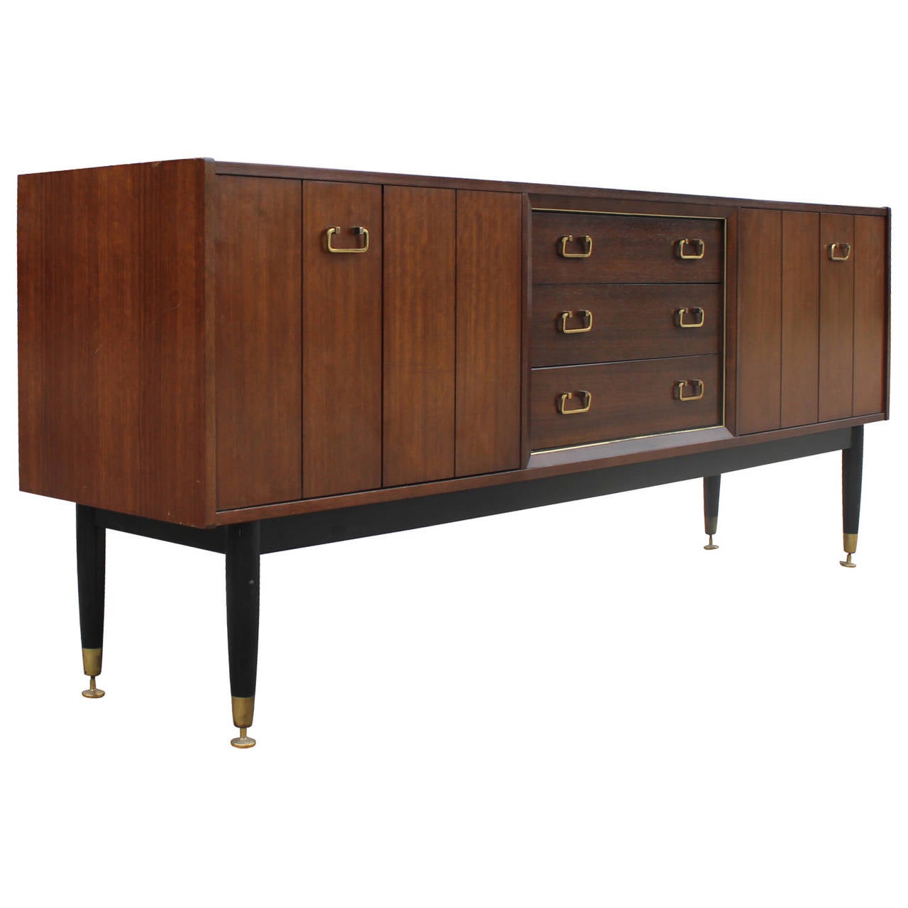 Stunning walnut sideboard or credenza with brass handles and folding doors. Case rests upon a black lacquered base. In great vintage condition. Can be made perfect at an additional cost. Excellent piece of furniture.
