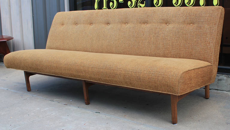 Great pair of Risom Style armless sofa with a walnut back. Sofas sit on straight walnut legs that continue to the back. Recent upholstery in good shape.