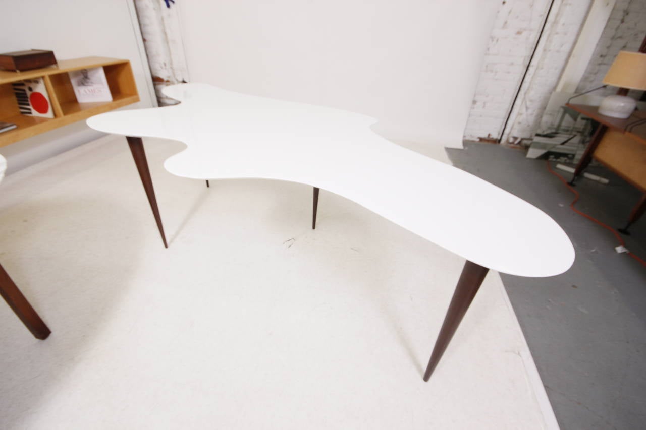 Very unusual Mid-Century Modern anamorphic desk or table with new white lacquer piano finish and ebony stained legs.
