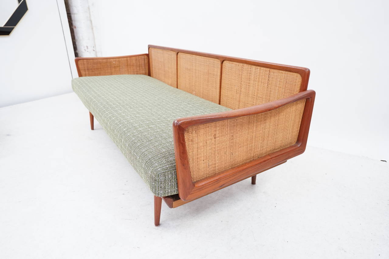 Beautiful Teak and Cane Sofa or daybed was designed by Peter Hvidt & Orla Mølgaard-Nielsen for France & Son in Denmark. It features a teak and woven cane frame.