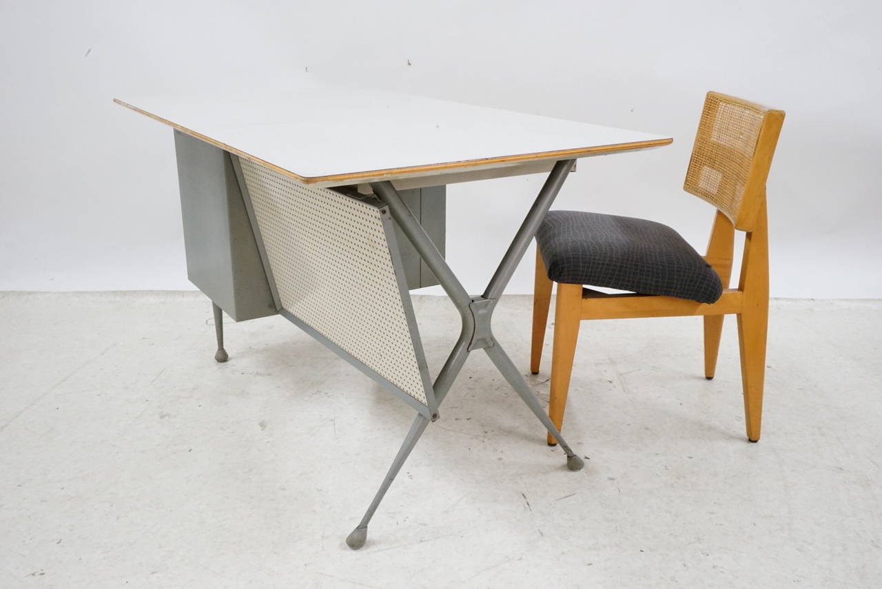 RAYMOND LOEWY desk with gray formica top, pegboard back and three white enameled drawers, on aluminum X-legs. Minor pitting. Unmarked. 29