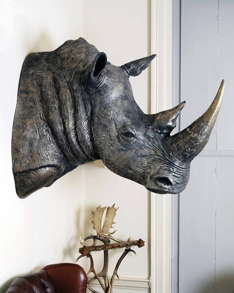 Resin moulded scale model of a rhino head finished in 
liquid bronze with natural patination. A 'Modern Grand Tour' Edition piece by Based Upon for James Perkins Studio 2012. 
Measuring 120cm high by 150cm approximately, the Rhino Head makes 
a