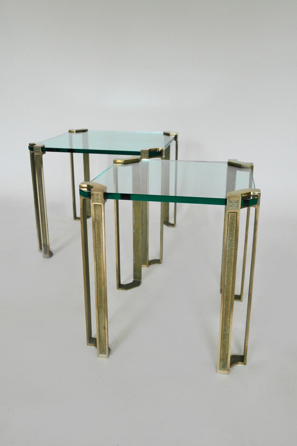 Pair of octagonal glass side tables with polished brass stem legs, the two tables are the same height but have different size glass tops. Attributed to Peter Ghyczy.

Larger piece is 45cm H x 51cm W x 51cm D
Smaller piece is 45cm H x 45cm W x