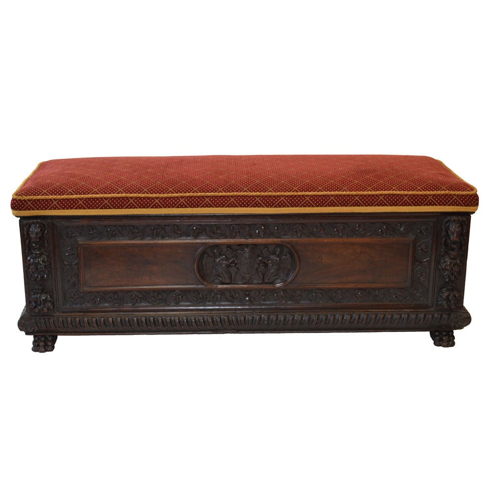 Jacobean-style oak coffer with lions head carvings on the front corners, gadrooned apron, and claw feet. Ample storage underneath the top. Included with coffer is a custom cushion in a red and gold velvet. Pristine condition, circa 1890.