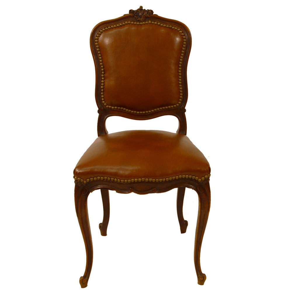 Set of six French Country dining chairs with cabriole legs, classical French hand-carved design on top and bottom, and new upholstery in a Stout leather.