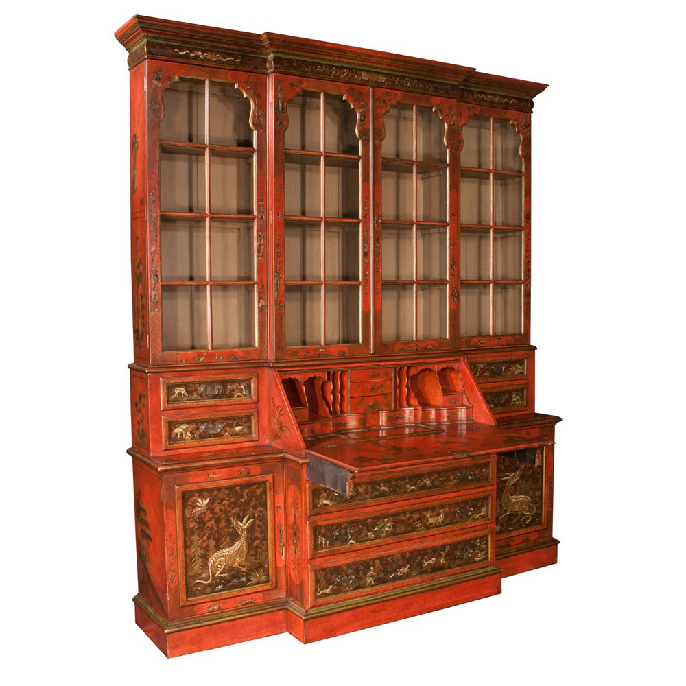 Crimson and gold chinoiserie lacquered breakfront bookcase with mullion glass doors, base has a center slant top desk and end sections have two drawers over panel doors. This breakfront is beautifully hand-painted, in full detail. In very good