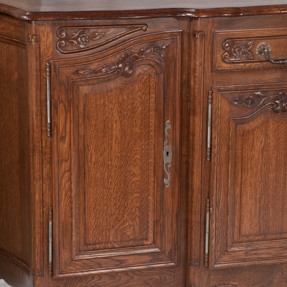 Country French oak shaped front buffet with carved panel doors on each end, center section has two drawers over two carved panel doors and having shaped carved apron, c. 1900...in very good condition with no deep scratches or cracks.