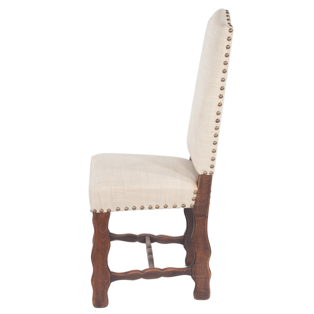 Set of six Country French dining chairs with sheepbone stretchers...linen upholstery in very good condition in a light neutral...adorned with large antique brass nailheads. Seat height on these chairs is 19.5