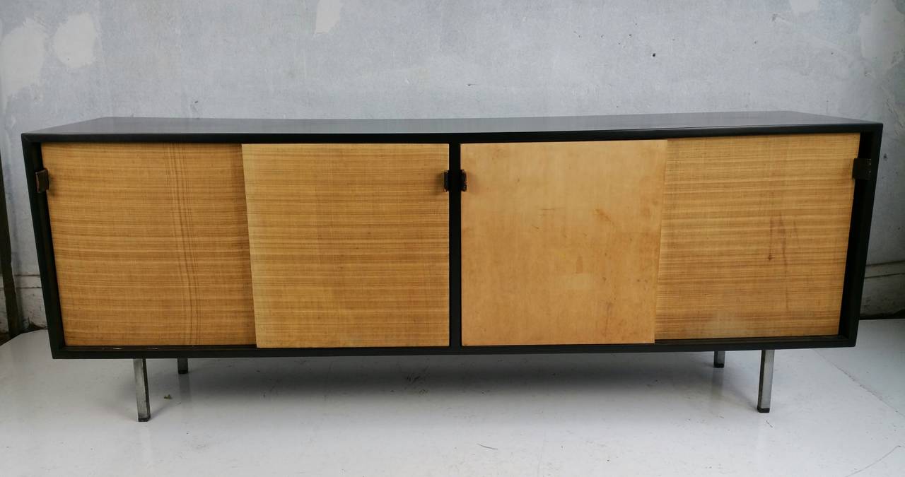Rare configuration,,Mid Century Modern  Black lacquer and grasscloth Florence Knoll credenza,, Manufactured by Knoll.. Early leather strapped pulls,, Chrome legs,Four sliding doors,,,File drawer,,2 ,shelves,,4  drawers,drawer and shelve..,