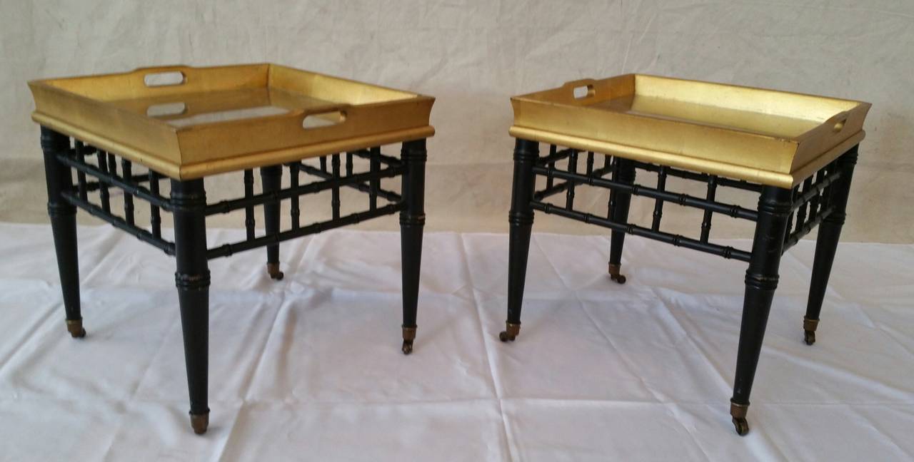 Wonderful pair of faux bamboo and gold gilt end tables. Asian inspired, attatched, handeled tray top. Manufactured by Medallion Limited.. Superior quality.