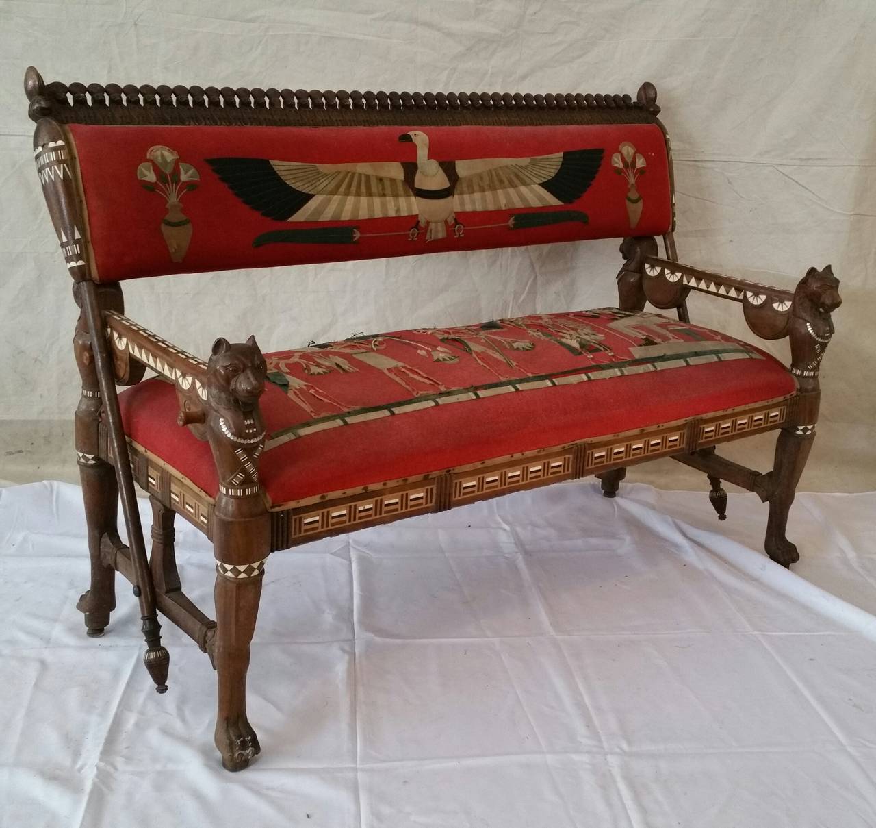 Egyptian Revival loveseat composed of rosewood inlaid with bone,ebony ,,Upholstered in a very rare felt hand stitched applique fabric in Egyptian motif,,original,The loveseat features reversable back and decorative Egyptian carvings,,Similar example