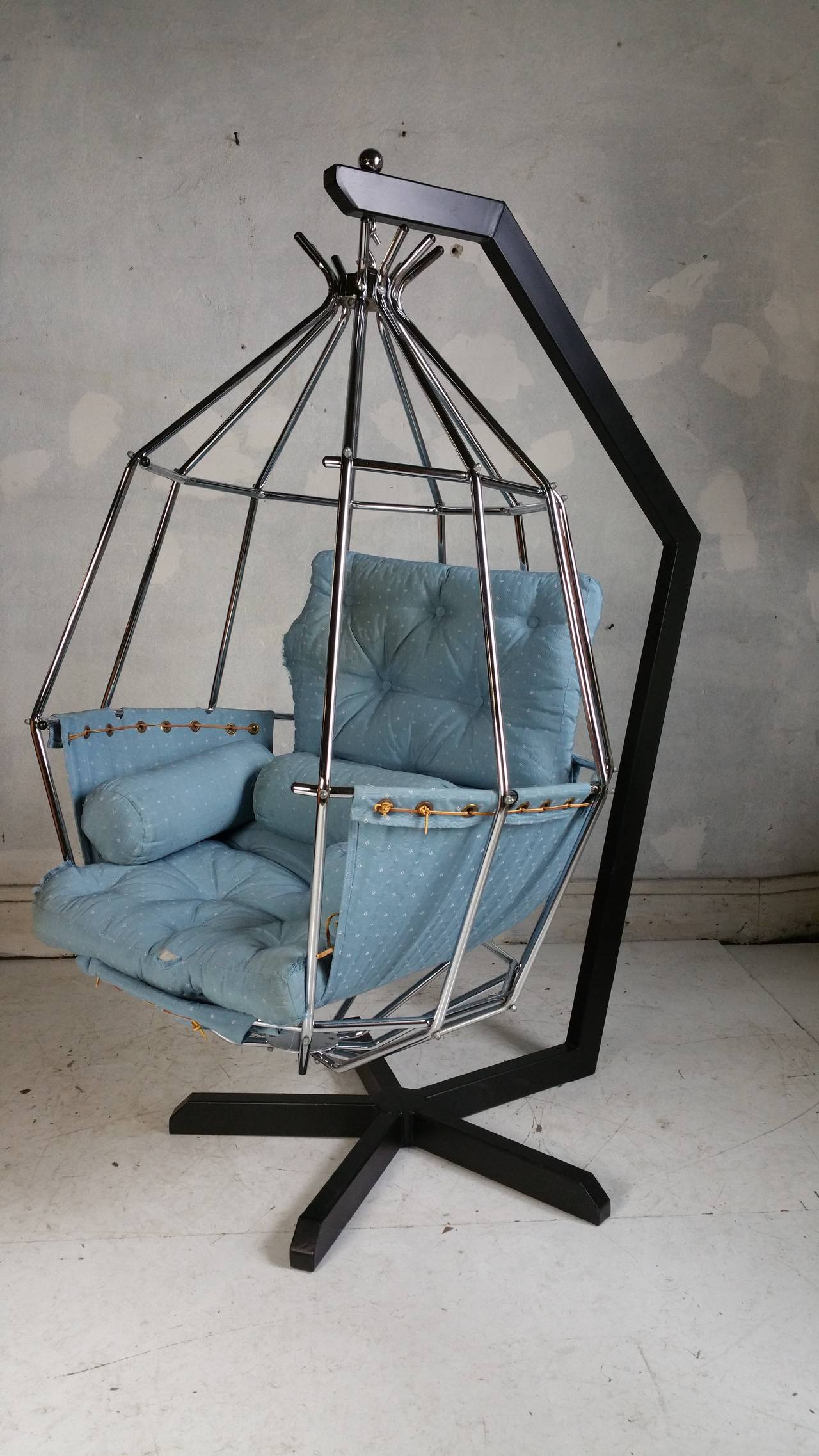 Hanging birdcage or parrot chair designed in 1970 by Swedish designer Ib Arberg, the angular black metal stand securely holds the chromed steel hanging birdcage chair, cradling the  sling and cushions. Stand height is 66