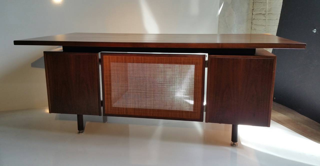 Stunning Mid-Century Modern executive desk designed by Jens Risom. Desk has all of the ammenities including, large file drawer, pencil drawer, pull-out tray, caned modesty panel, stainless steel levelers. Beautiful hand pulls, trimmed in stainless,