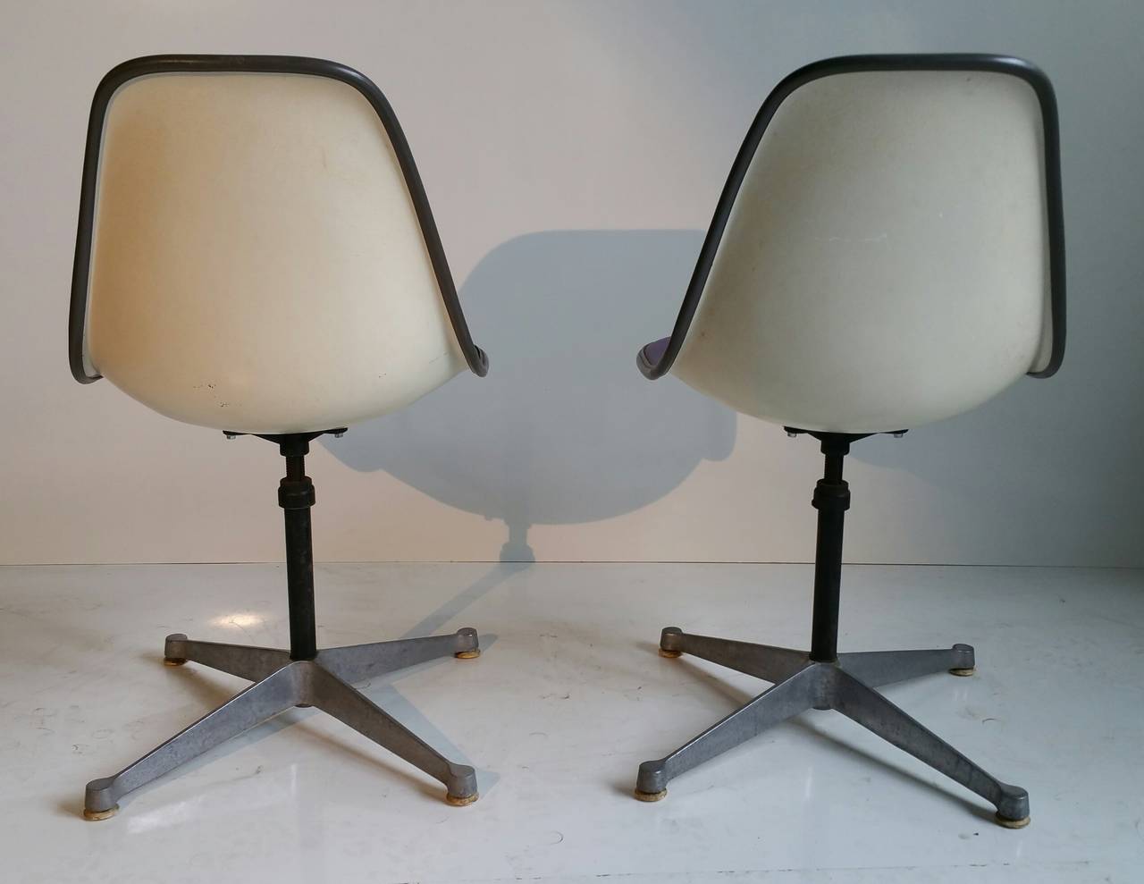 Nice pair of adjustable height swivel chairs designed by Charles and Ray Eames,, Retain original Girard naugahyde padded fiberglass shell as well as early cast aluminum 4-star base,,Classic Mid Century Modern.