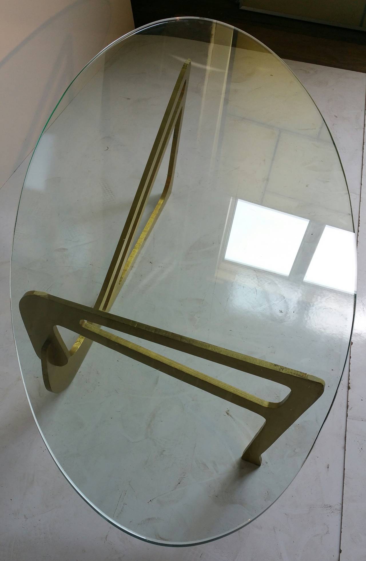 Solid brass sculptural base the brass version of  the famed organic Noguchi coffee table. Original thick oval glass