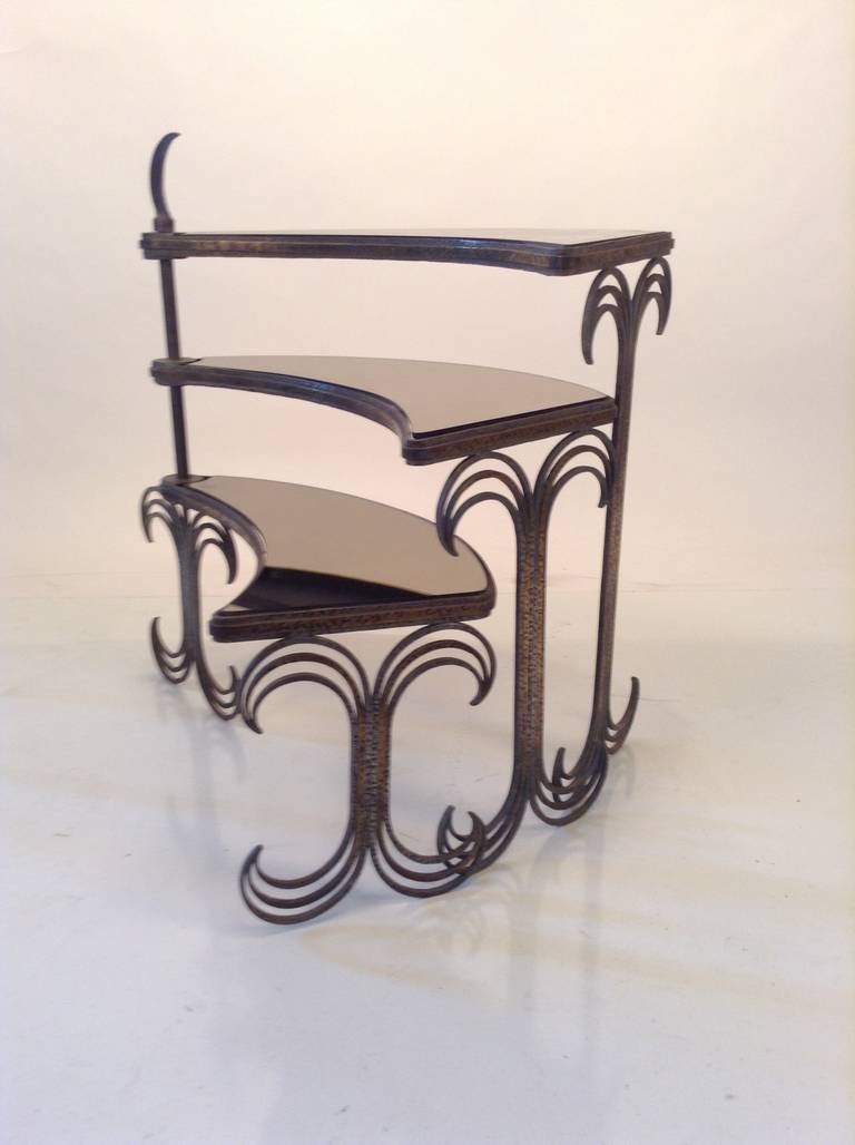 Exceptional art deco table in the manner of Edgar Brant. Wedge shape articulating swivel tops in smoked glass.