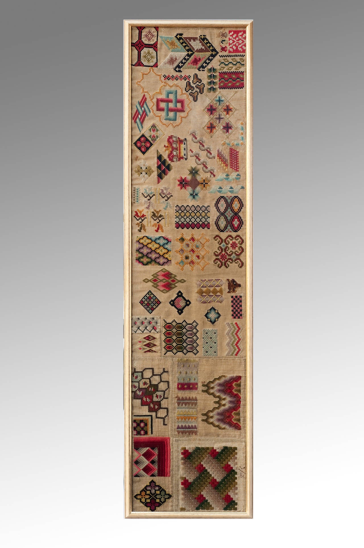 A very decorative and colourful mid-19th century spot sampler most probably worked in a professional workshop and illustrating a diversity of various patterns in the Berlin style, including Bargello stitch-work it is an antique sampler with some