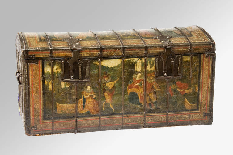 A domed top, leather painted, iron-bound chest with two lock plates and carrying handles. Dated to the front and to one side 1605. The painted panels depicting figures within chateauxed gardens the front panel showing a musical soiree including a