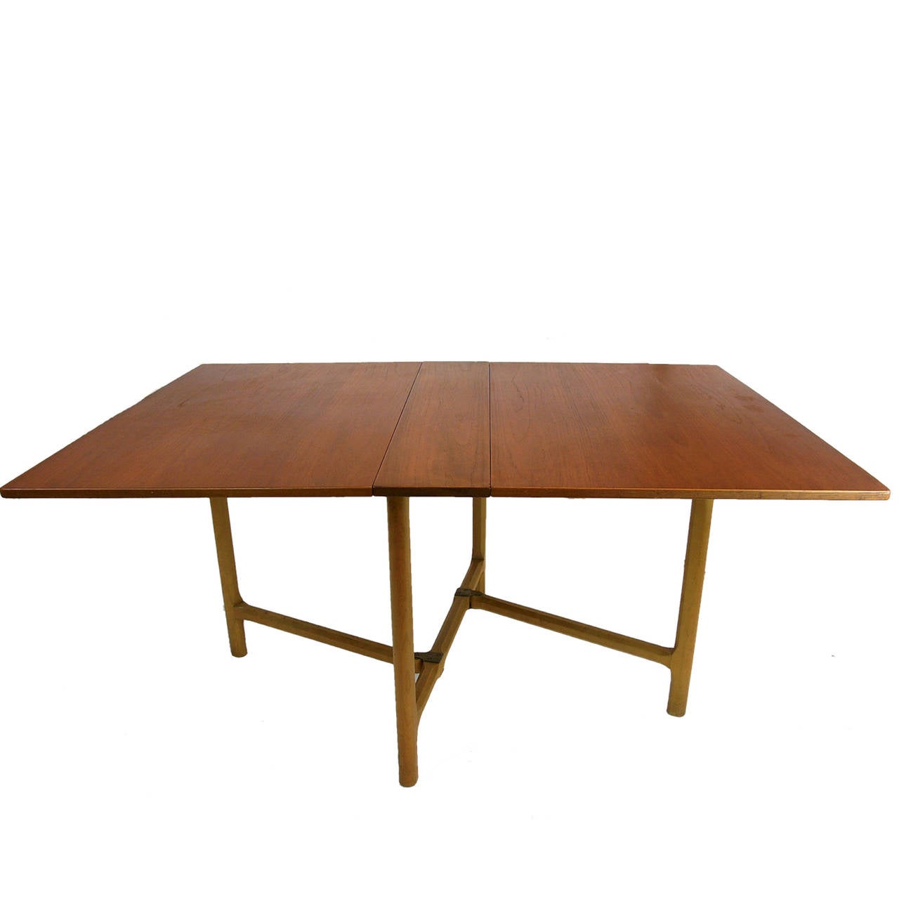 A versatile and rare Bruno Mathsson table in teak with sculptural beech legs, and brass detail. The table compacts to an easy to store 9