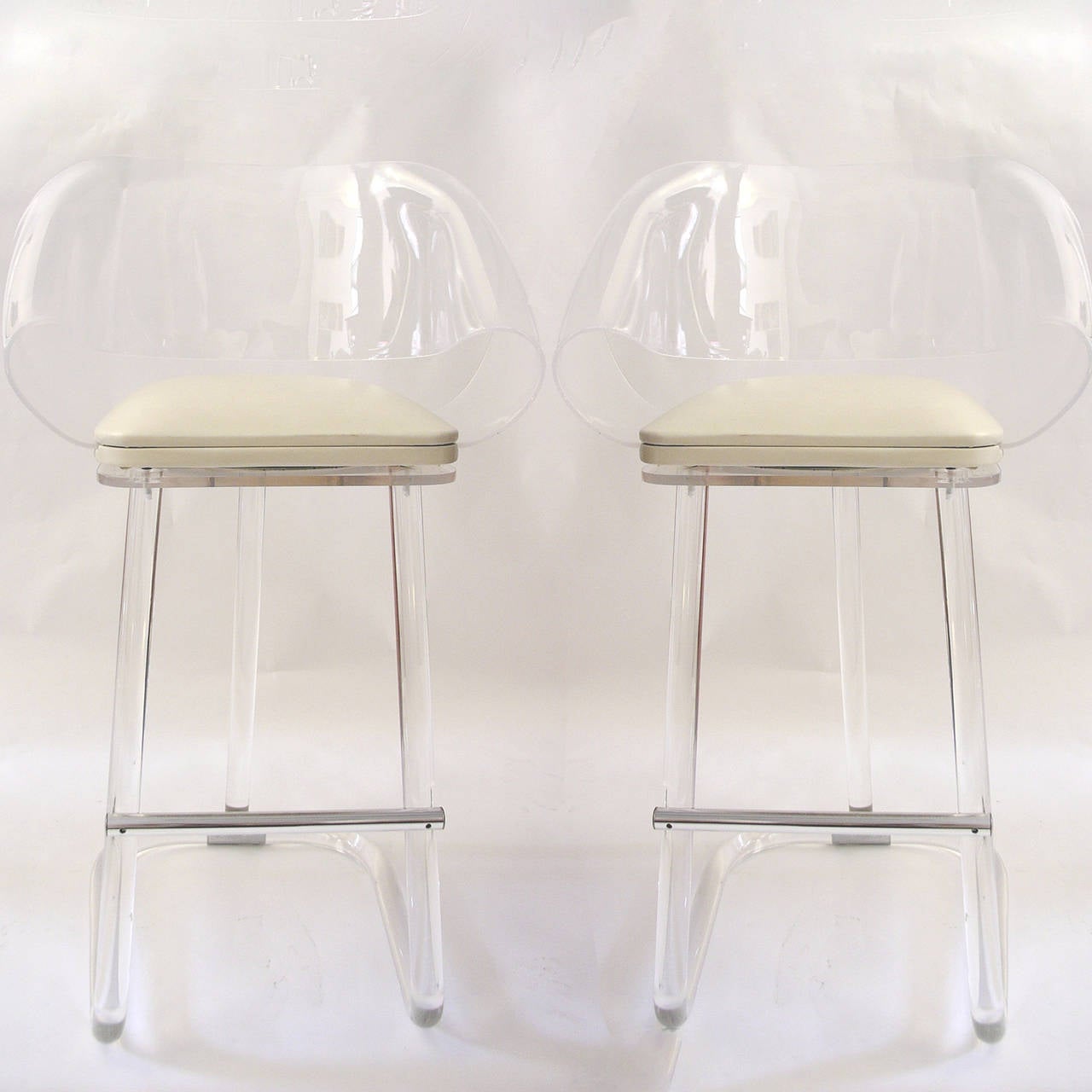 Pair of stunning swivel sculptural bar stools with off-white naugahyde seats.
2 pair (4 stools)  available. Priced per pair.