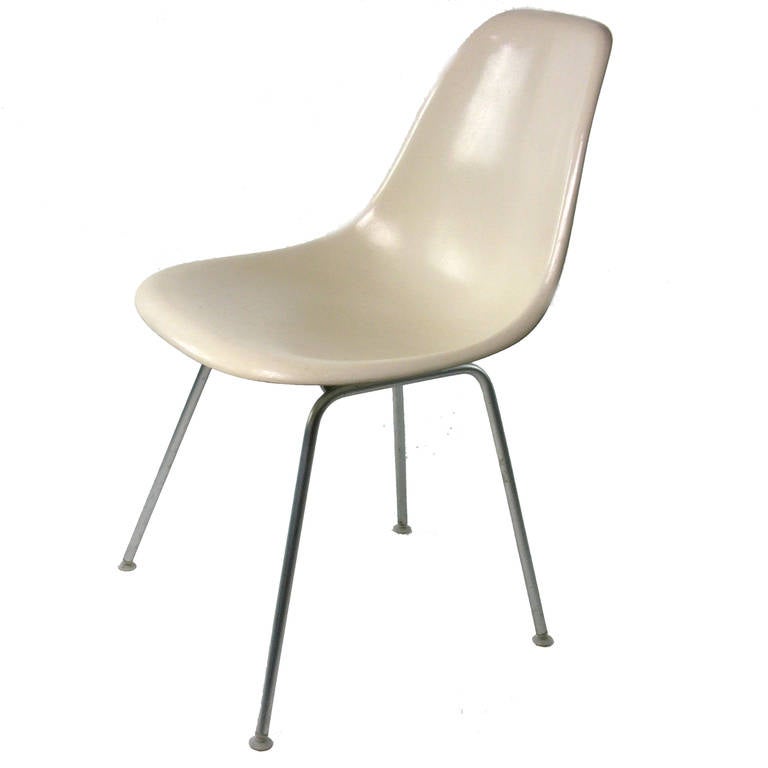 A large grouping of Eames shells chairs in cream color (parchment) .