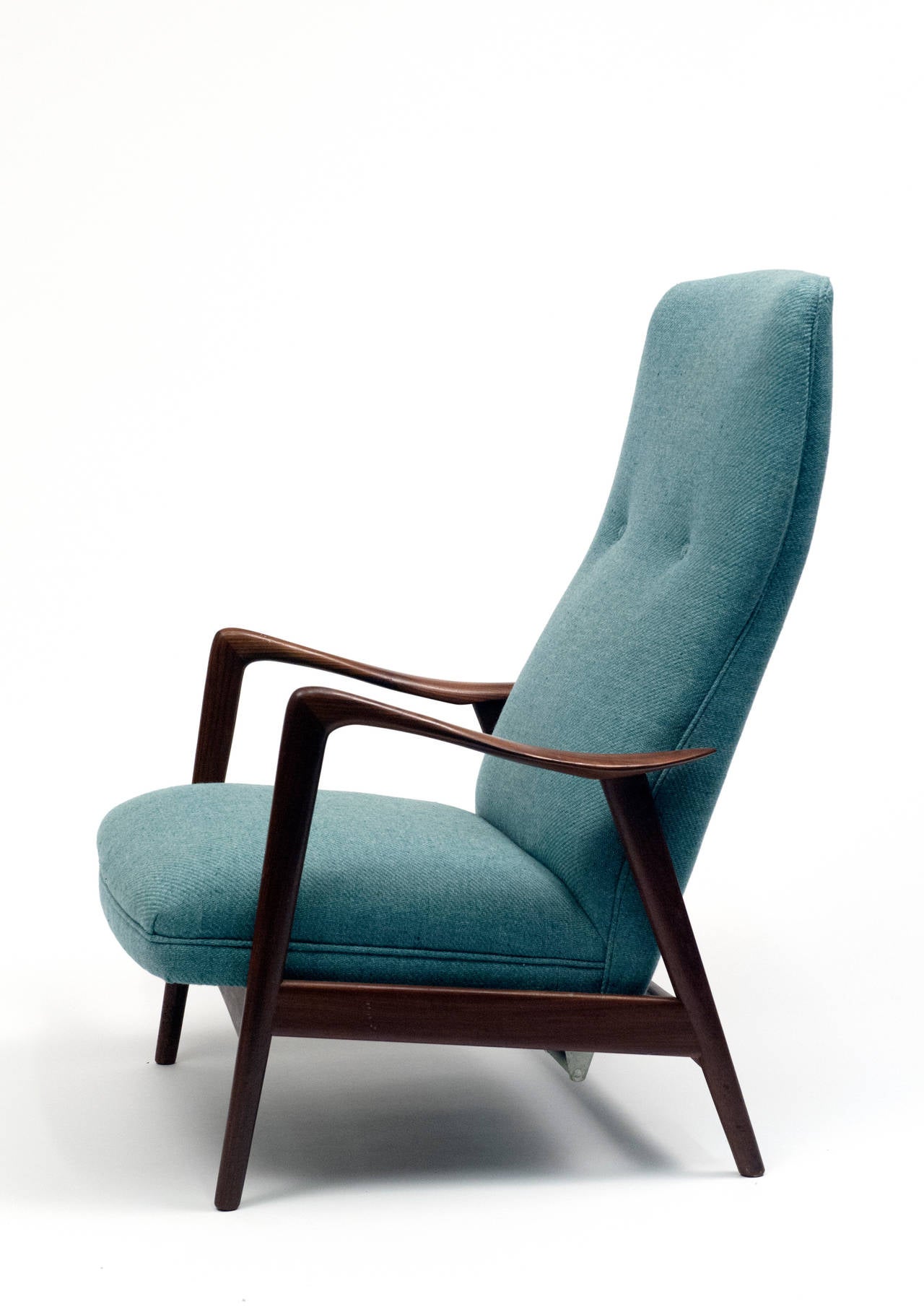 Well made high back lounge chair by Folke Ohlsson for Dux. High seat back has spring tension allowing for rocking motion and locking reclining positions.  Solid teak frame and upholstery are in excellent condition.