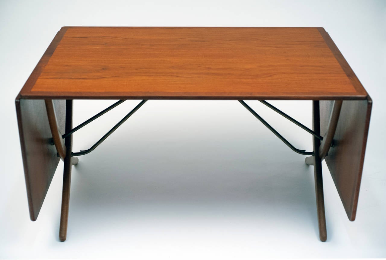 Hans Wegner teak dining table manufactured by Andreas Tuck.  Beautiful teak top with oak legs.  Drop-leaves ingeniously designed to be attractive and function easily.  The table has original patina and is in good condition.

Measures 50
