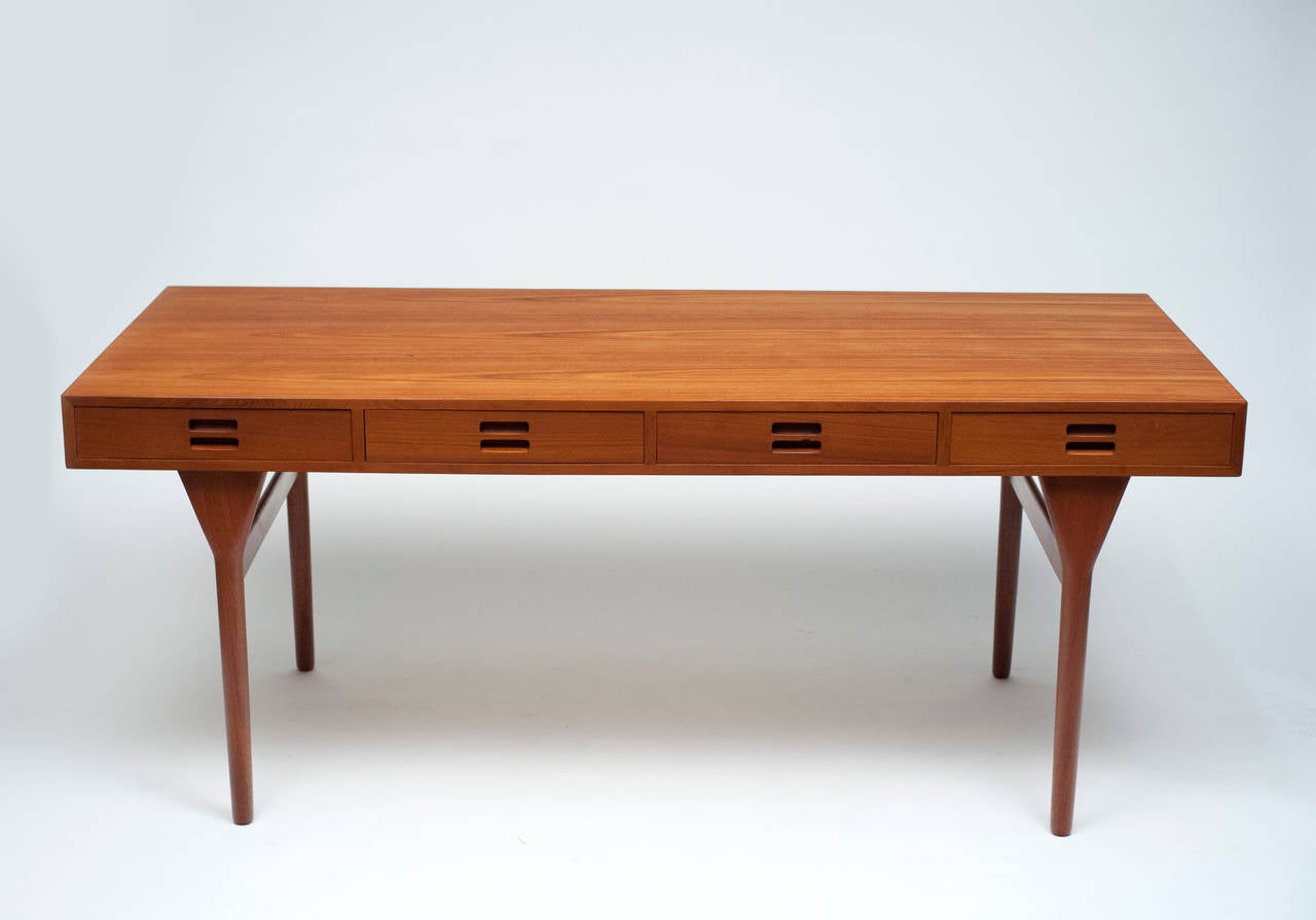 Desirable four-drawer teak desk designed by Nanna Ditzel and manufactured by Søren Willadsen Mobelfabrik. Back of desk is finished, so desk works well freestanding in a room. Measures: 68