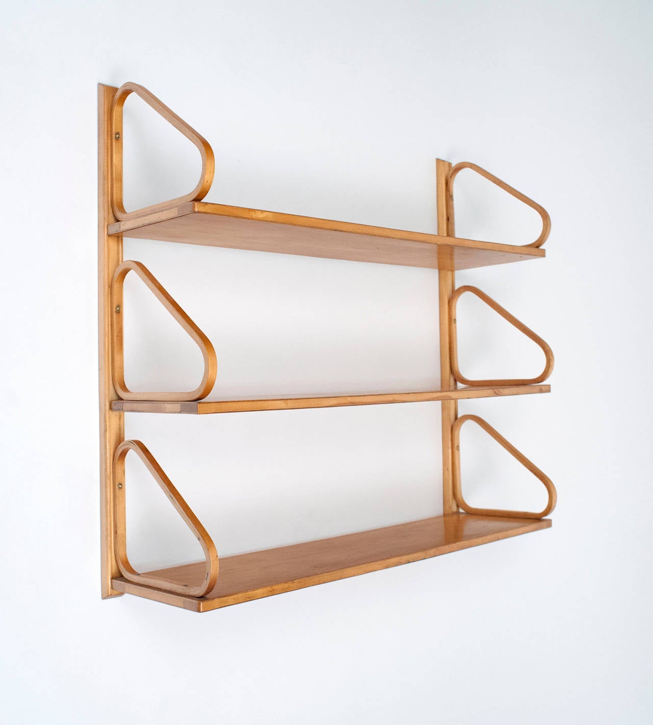 Rare set of three shelves by Finnish designer Alvar Aalto. Complete with original hanging bracket. Birch has developed a beautiful honey colored patina. Condition is excellent. Shelves measure: 33.5