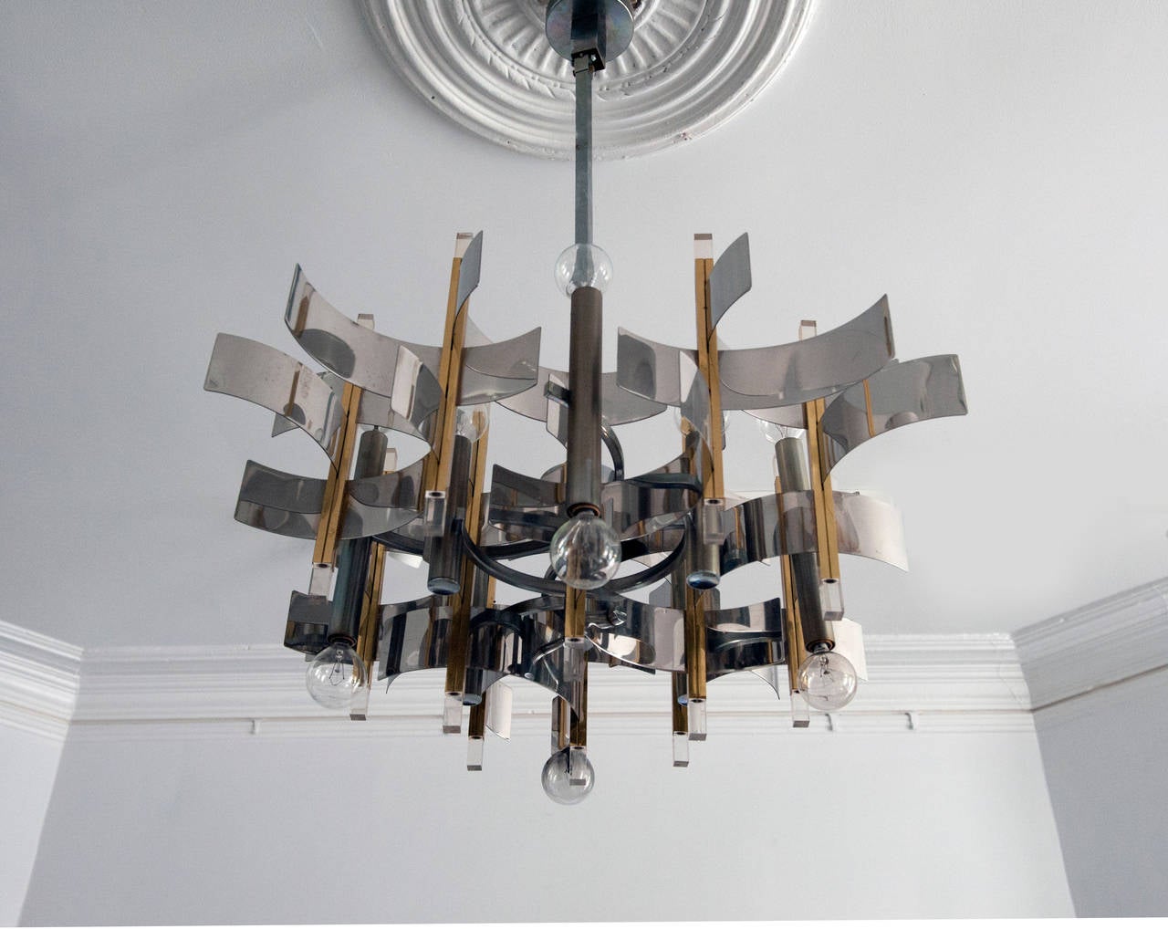 Dramatic twelve-light brass and chrome chandelier with Lucite accents by Gaetano Sciolari. Chandelier is complete with original rod and ceiling cap. Measures 29