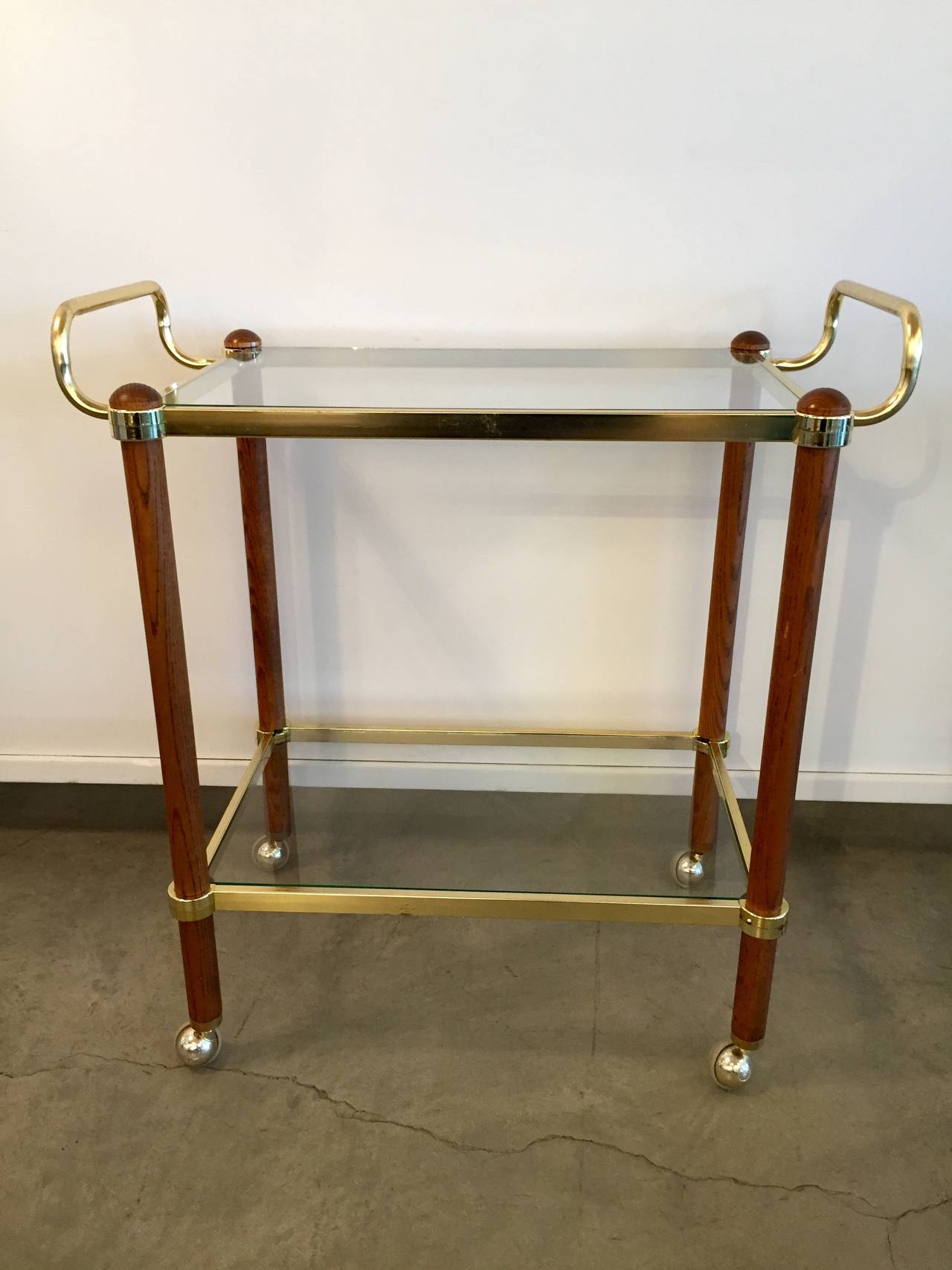 Two-tier glamorous high gloss brass, glass and redwood mid-century modern Italian bar cart. This piece just begs for a high glam cocktail hour!
