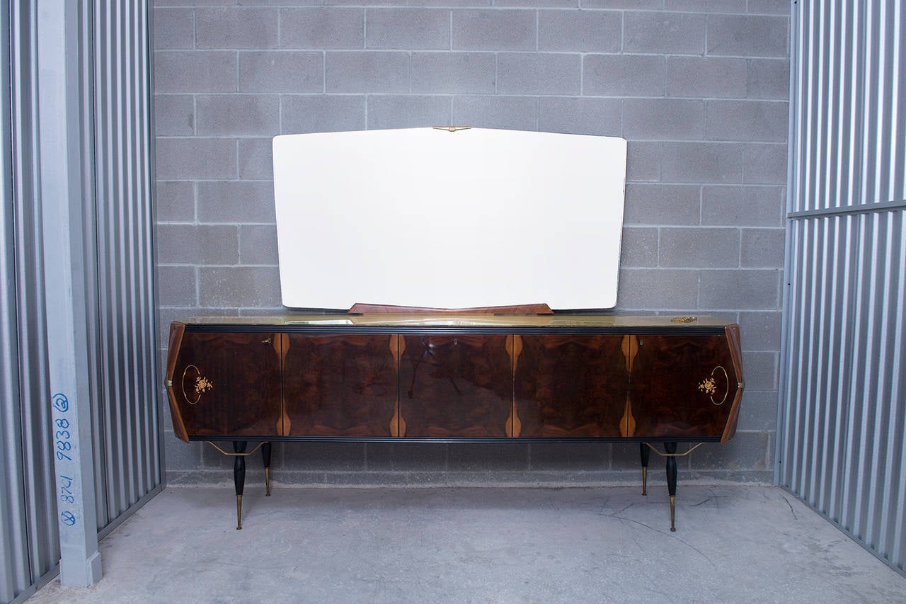This vintage MCM Italian wood and brass sideboard with monumental mirror is truly a very, very special piece. The artistry and design in this sideboard is quite rare. This piece is a true example of MCM Italian architectural rigor mixed with a