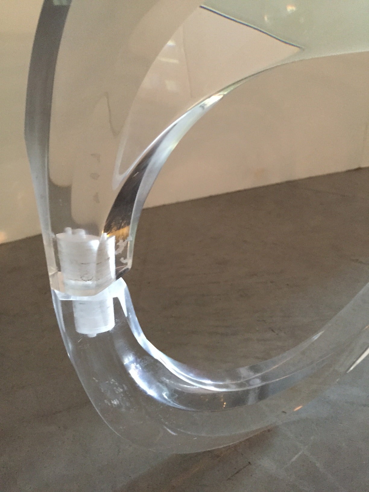 Loop to loop in fluid Lucite glamour! Offered is a sculptural Lucite modern base with an oval glass top.