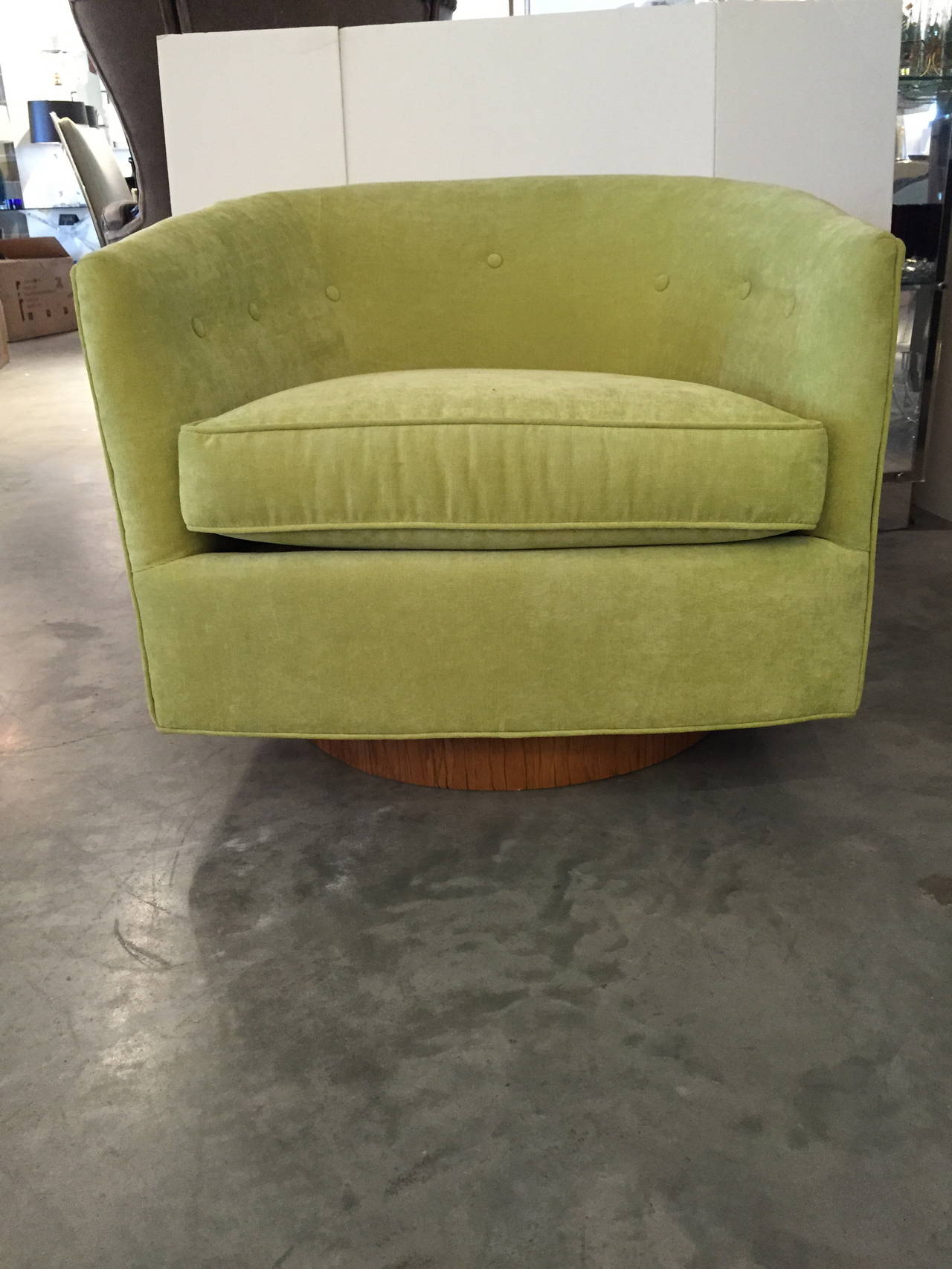 Offered are a two Milo Baughman tilt and swivel chairs with a walnut base.  One of the pair has been re-upholstered in a celery green velvet.  The other has not been re-upholstered; however, a supply of the same fabric will be given with the sale. 