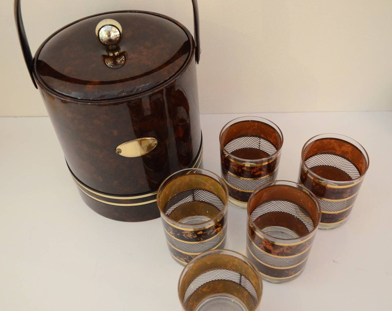 Georges Briard faux tortoiseshell and gold band ice bucket with set of five coordinating faux tortoise and gold band tumblers. Ice bucket is 8.5