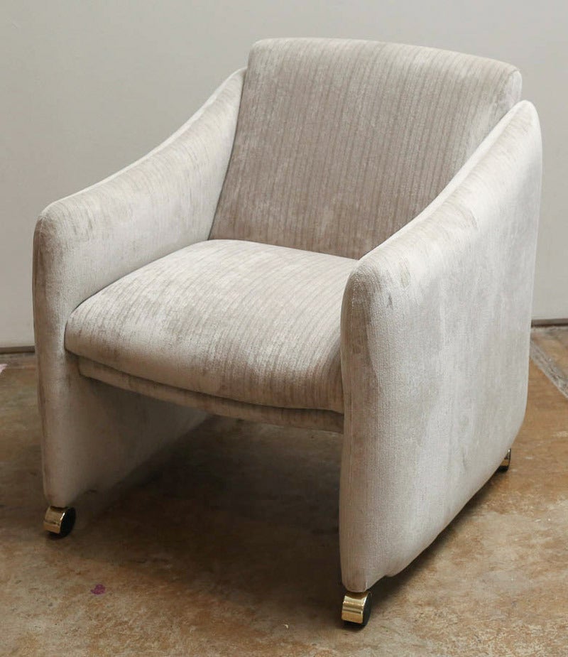 Offered are a pair of sleek Milo Baughman style lounge chairs on brass casters, newly upholstered in platinum gray subtle corded velvet made from eco-conscious bamboo fabric.