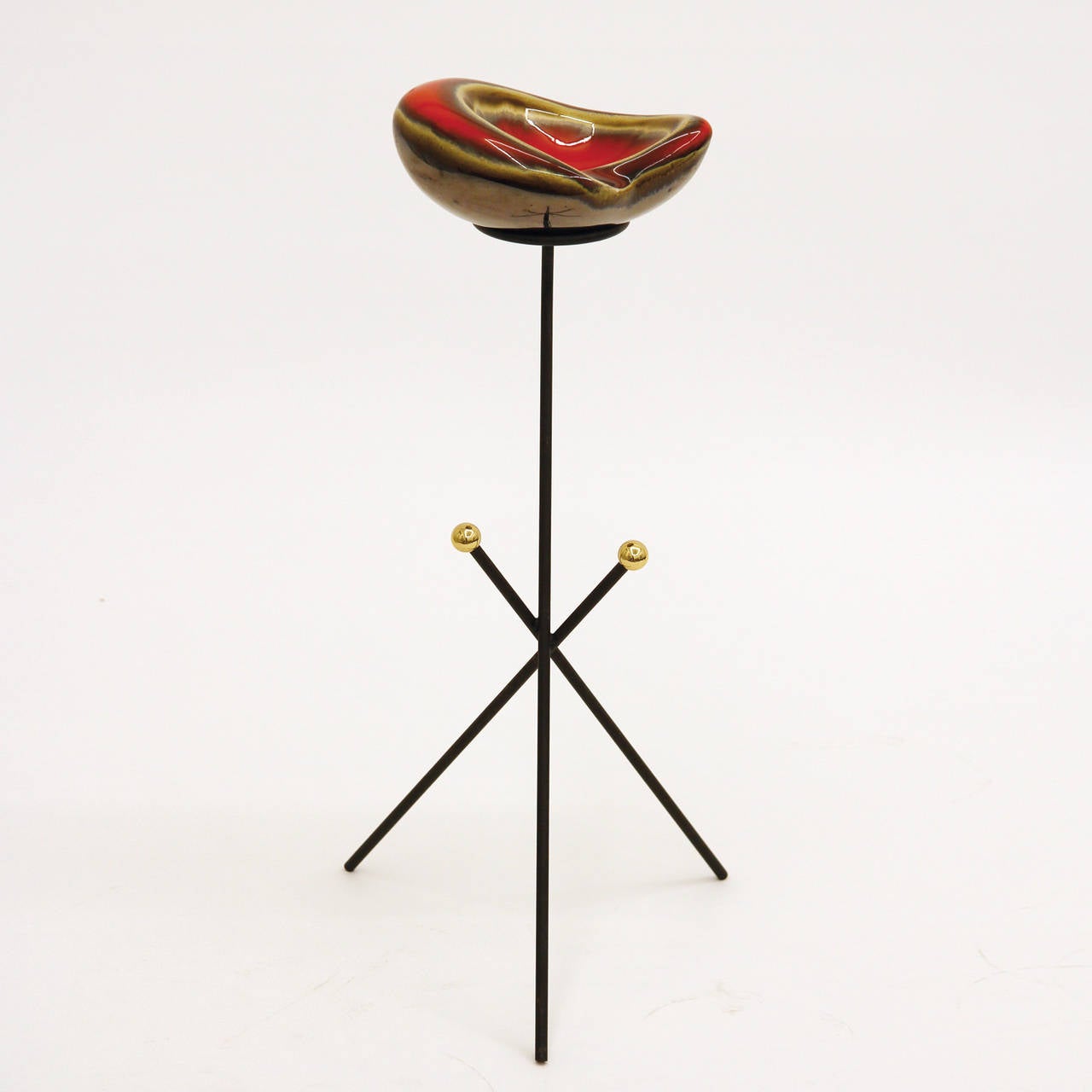 Elegant modernist ceramic ashtray or catch-all on a blackened iron tripod stand with two nice brass accent knobs. Interesting organic glazing to the ceramic ashtray which contrasts nicely with the stark Minimalist base. Very good original condition