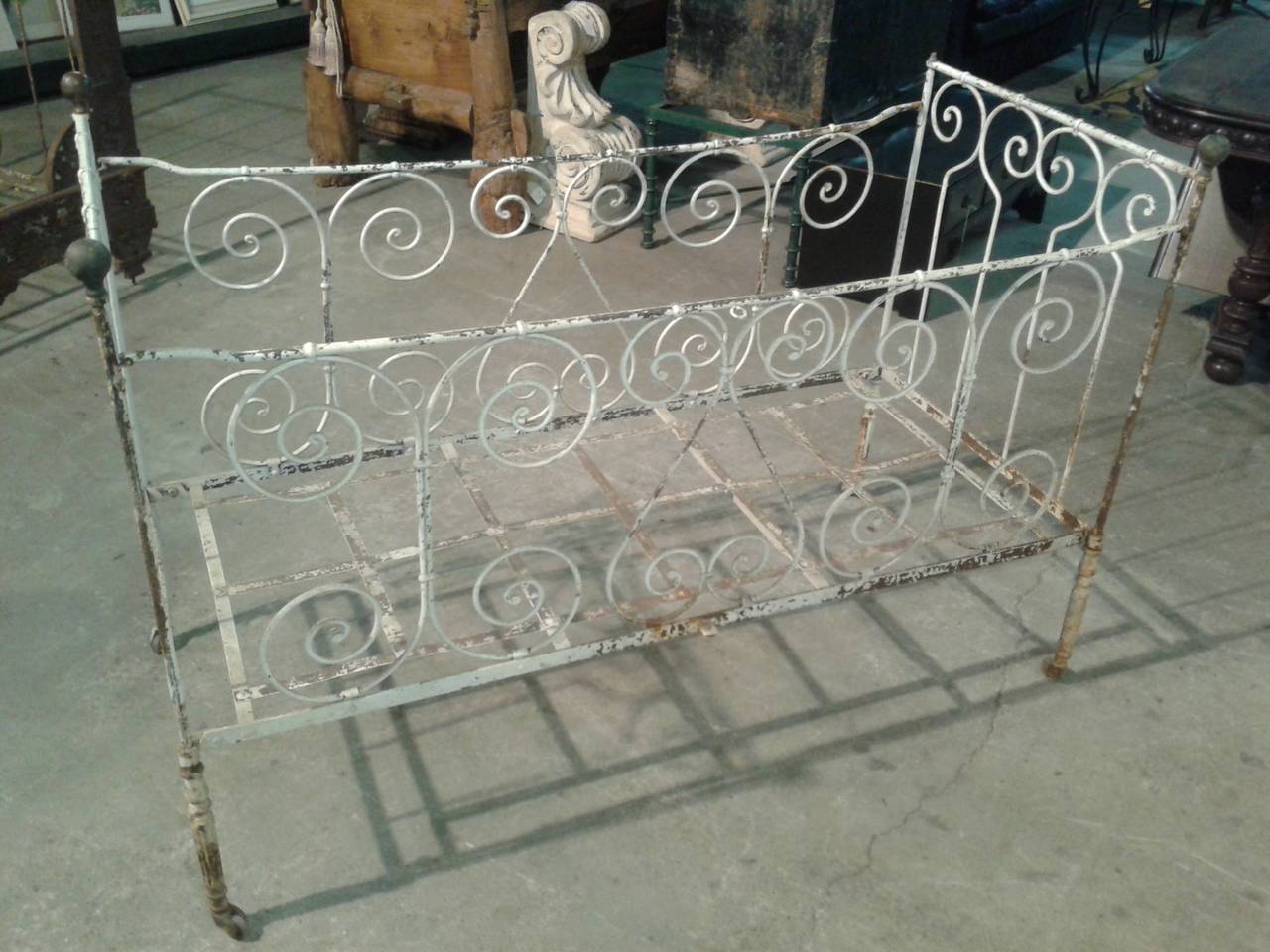 Antique French wrought iron scroll baby bed on casters. Very sweet white bed that would be a perfect as your family's heirloom. Four original casters are working. The bottom of the bed is 12