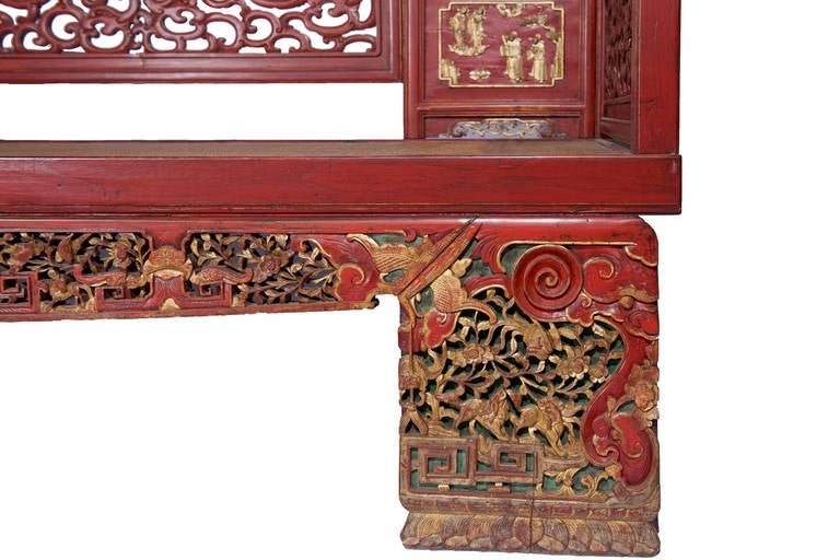Red muted lacquer finish on this antique Chinese opium bed or wedding daybed with carved wood canopy details abound on what is an amazing piece. Delicate and exquisite gold gilded carvings and medallions depicting Chinese life pervade the canopy,