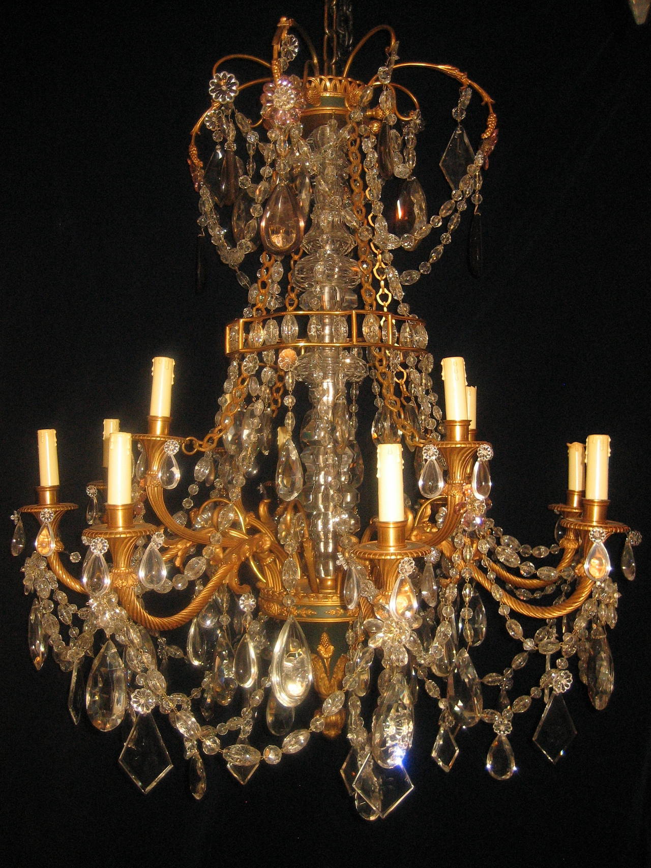 A fine antique French Louis XVI style gilt bronze, patinated bronze and cut crystal multi-light double-tier chandelier of great quality embellished with cut crystal prisms and chains, 19th century.