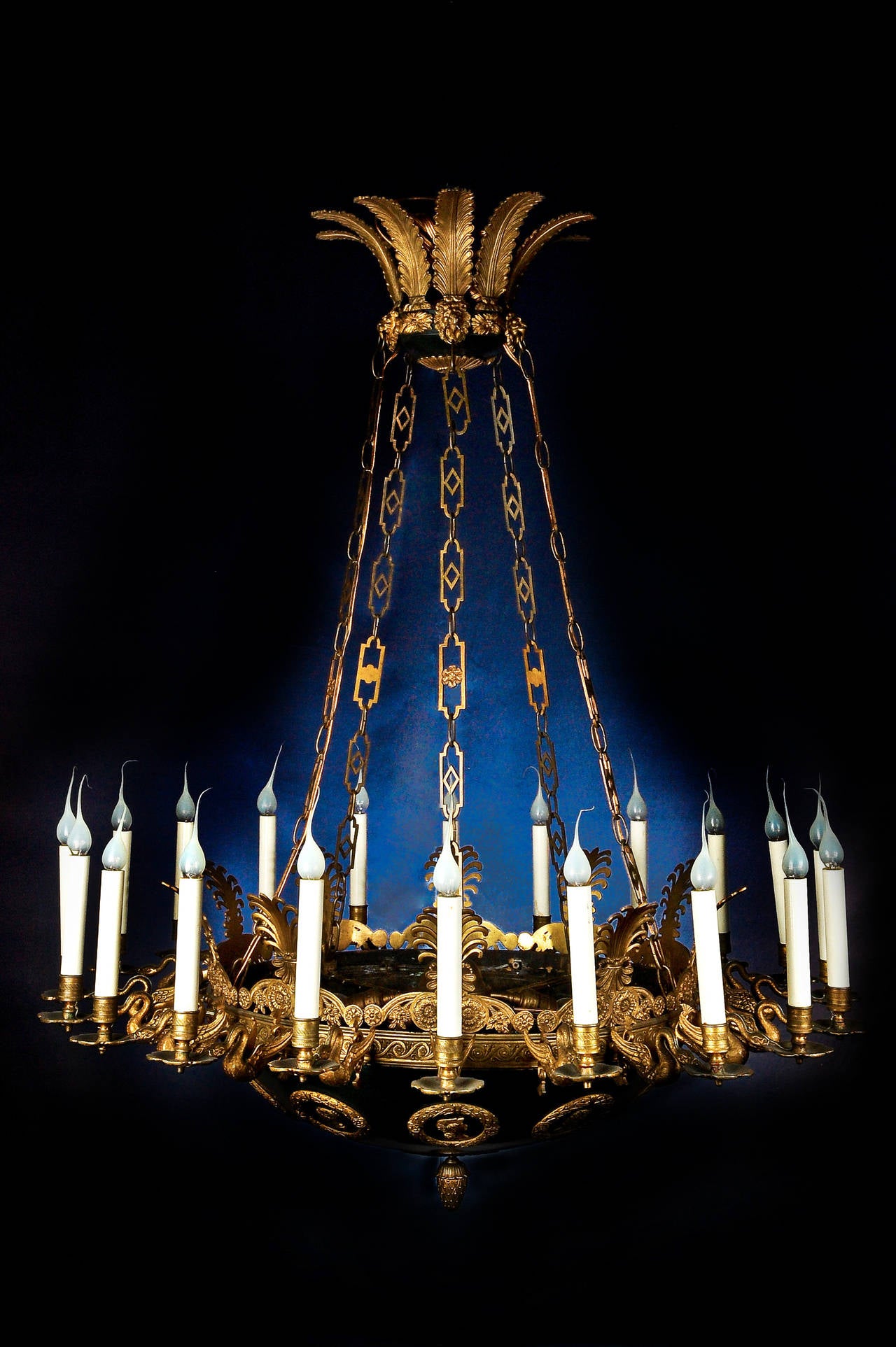 A spectacular and large antique French Empire neoclassical gilt bronze and patinated bronze multi-light chandelier. This fine chandelier is embellished with gilt bronze swan arms and embellished with military figural masks and lion masks.