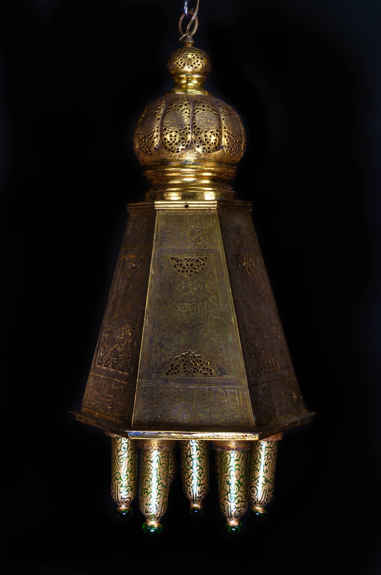 Un lustre lanterne multi-lumière de style marocain islamique octogonal unique en laiton réticulé et en verre doré vert, finement détaillé et agrémenté d'écritures islamiques et d'abat-jour en verre soufflé vert décoré de dorures.