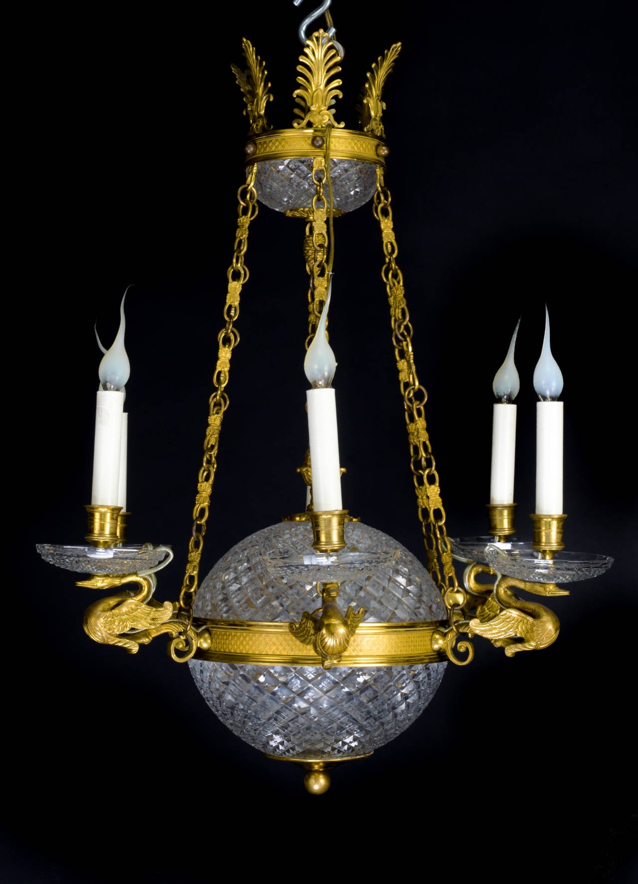 A fine antique French neoclassical style gilt bronze and cut crystal ball form chandelier embellished with a cut crystal central ball and decorated with six gilt bronze swan arms.