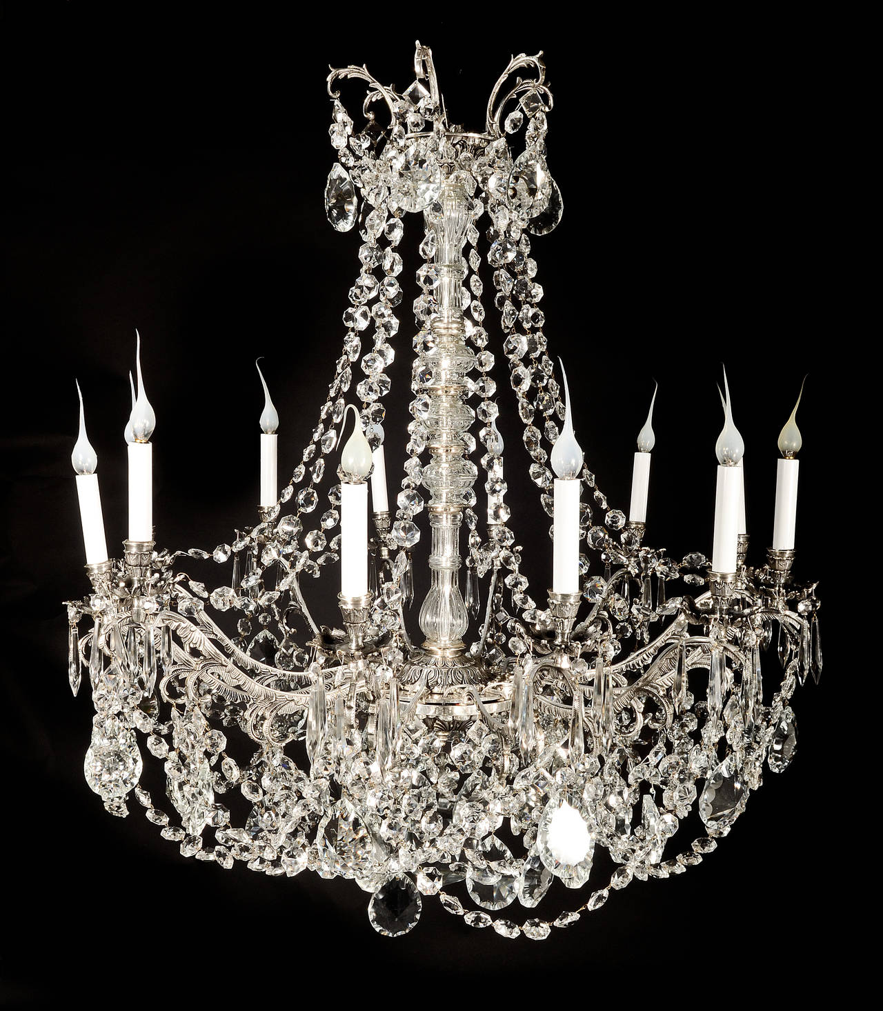 A large antique French Louis XVI style silvered bronze and cut crystal multi light chandelier embellished with cut crystal chains and prisms.