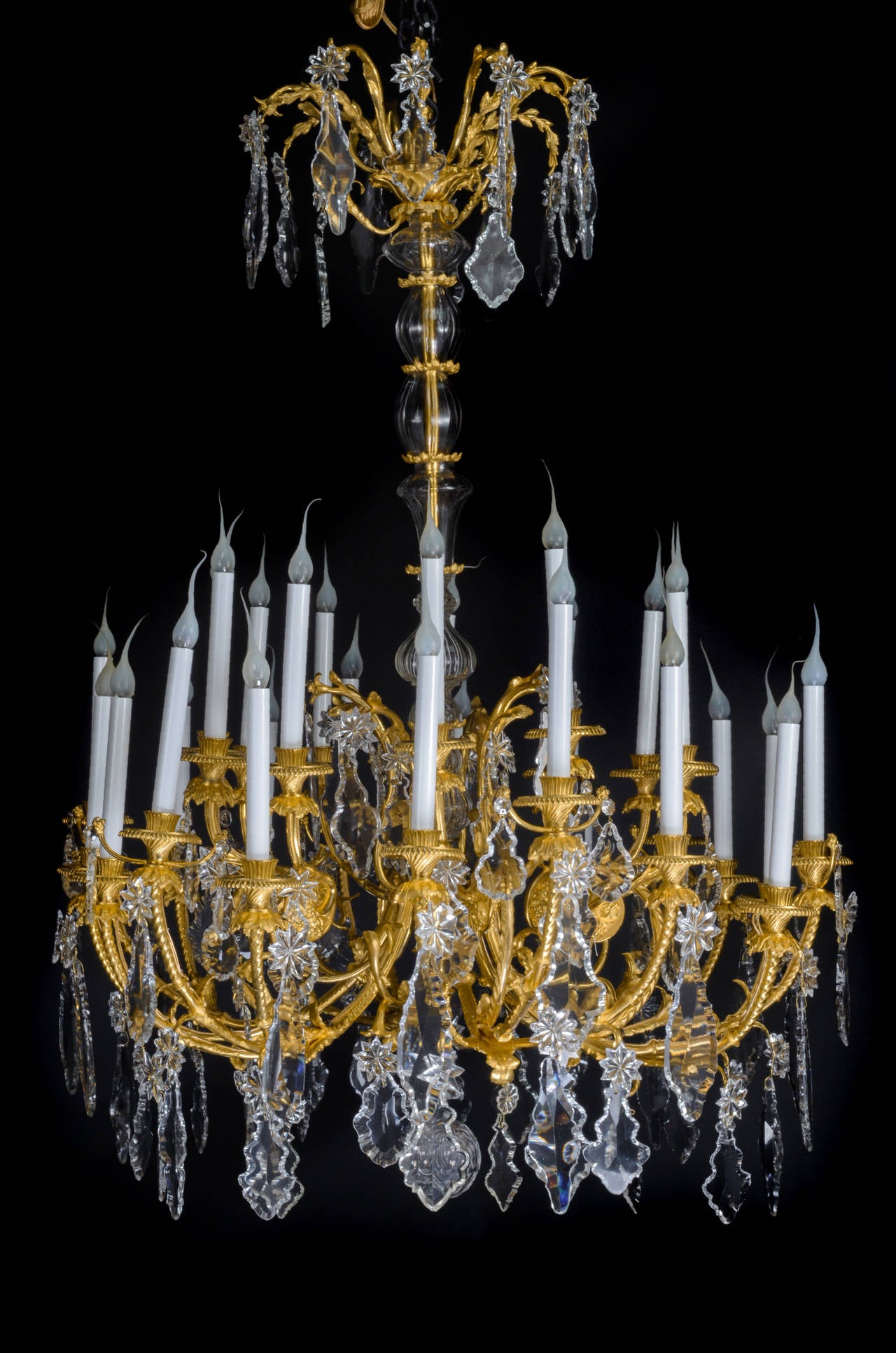 Un spectaculaire et grand lustre ancien français de style Louis XVI en bronze doré et cristal taillé de Baccarat, à trois niveaux et à plusieurs lumières, d'une superbe facture, agrémenté d'un axe central en cristal taillé, de grands prismes en