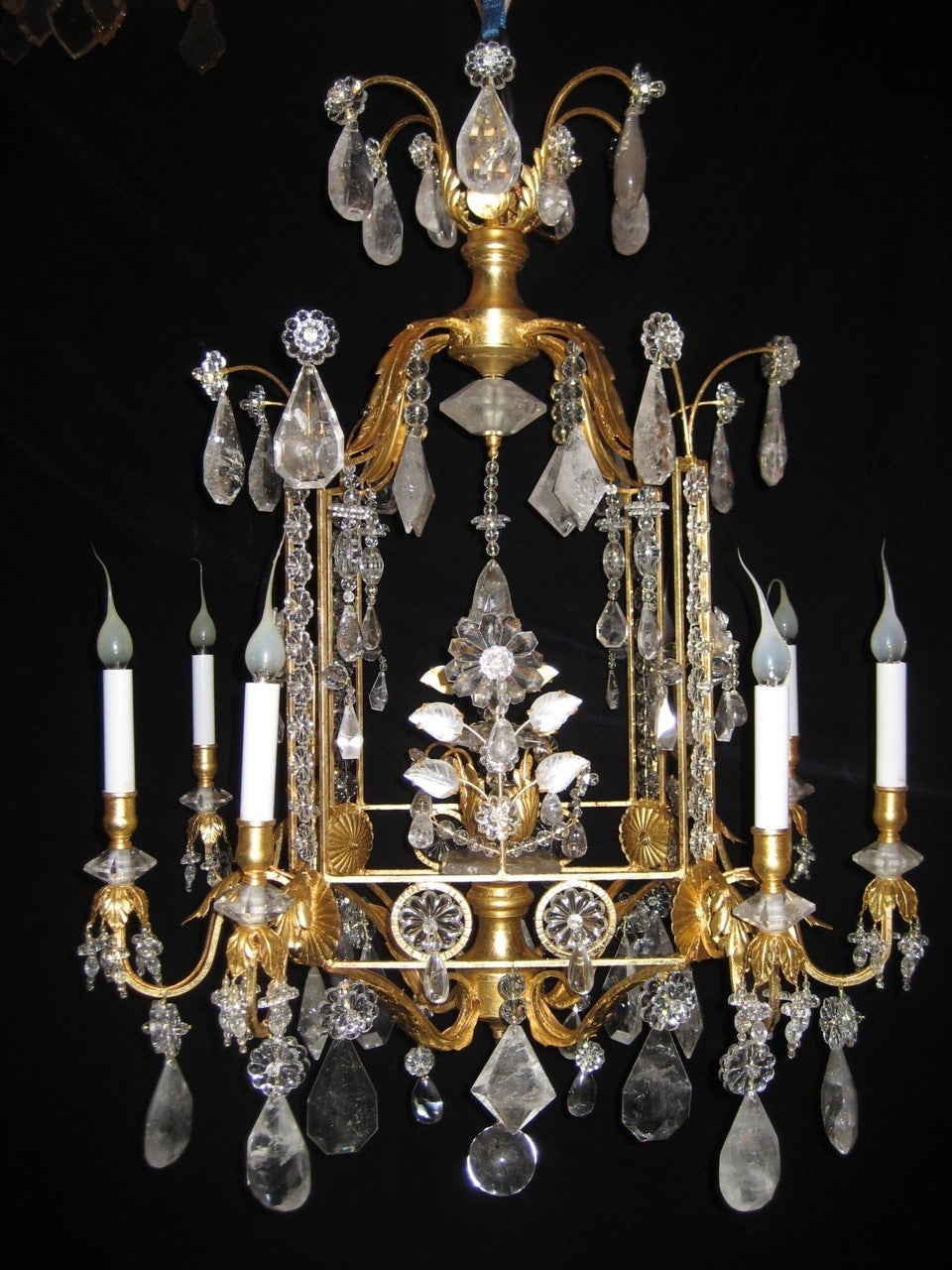 A Pair of Fine Louis XVI style gilt and cut rock crystal multi light square form lantern chandelier embellished with cut rock crystal flowers, prisms, leaves, crystal beads and finally adorned with a cut rock crystal ball in the style of Bagues.