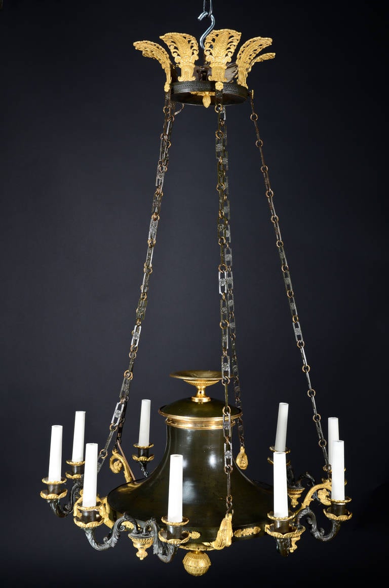 Superbe lustre néoclassique de style Empire français ancien, en bronze doré et bronze patiné, à plusieurs lumières, agrémenté d'une urne centrale.